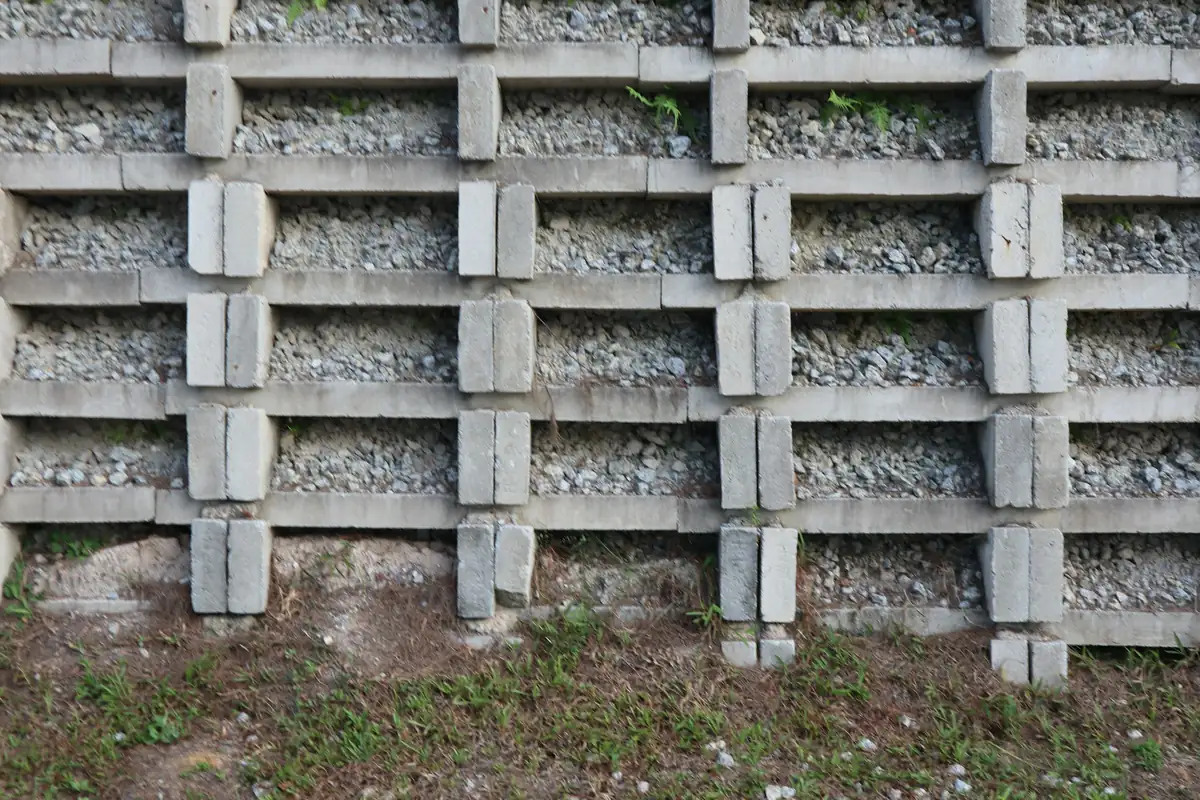 Precast concrete crib retaining wall of interlocking units filled with crushed stone