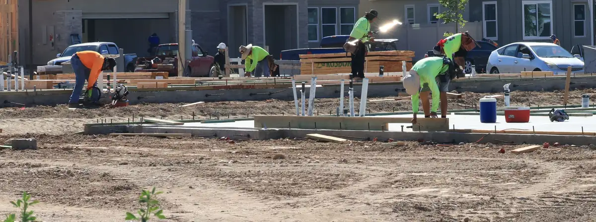 Crew setting forms and plumbing stub-outs for slab-on-grade concrete foundations