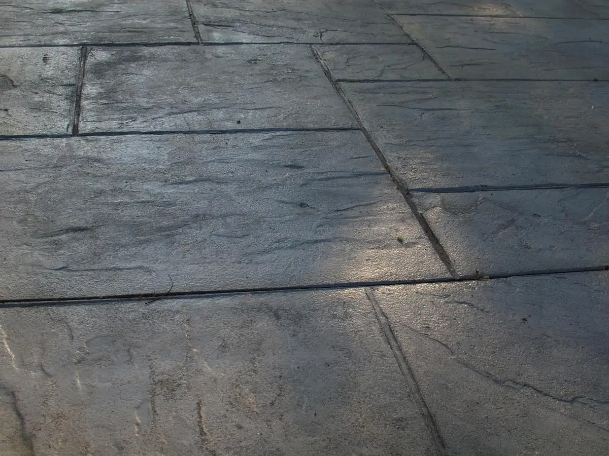 Sealed gray stamped concrete patio in an ashlar slate pattern with imprinted stone joints